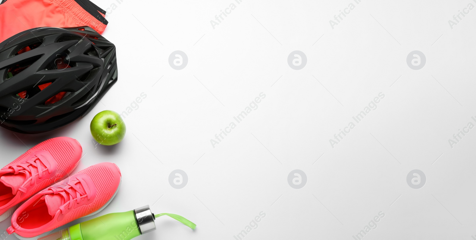 Photo of Flat lay composition with different cycling accessories and clothes on white background, space for text