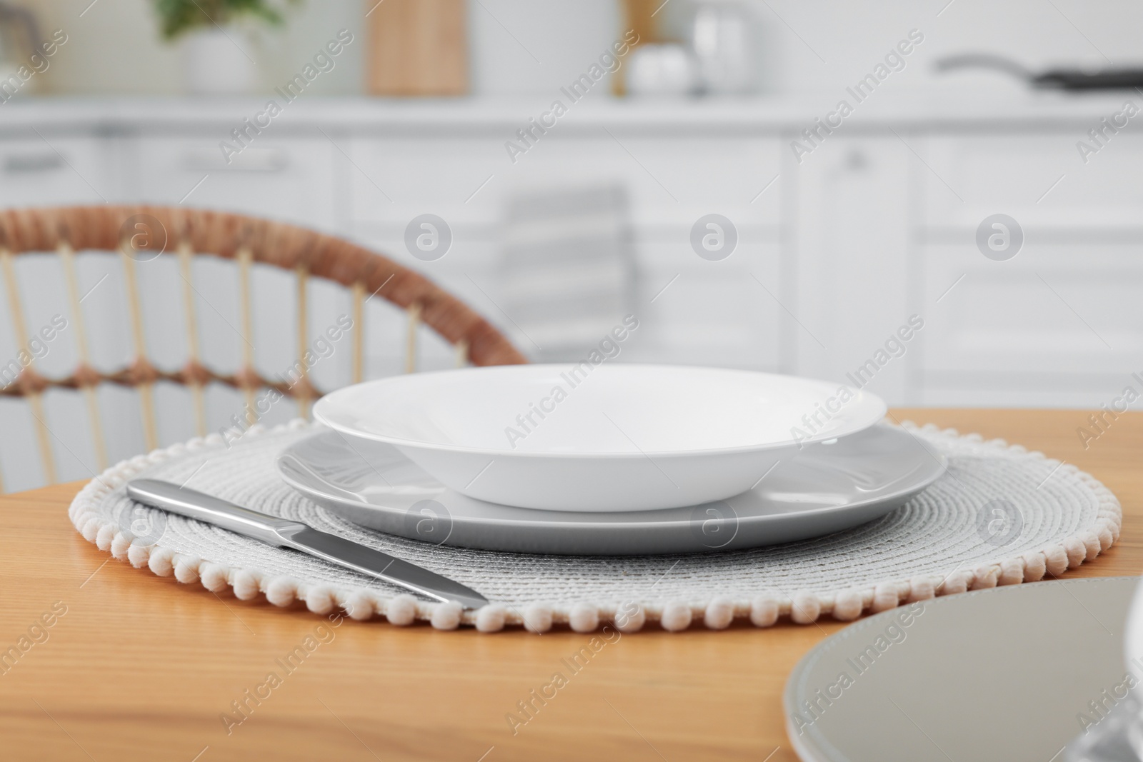 Photo of Stylish ceramic plates and cutlery on wooden table in kitchen