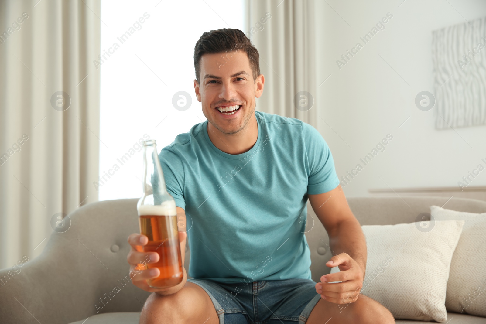 Photo of Man drinking beer while having online video conference at home, view from web camera. Social distancing during coronavirus pandemic