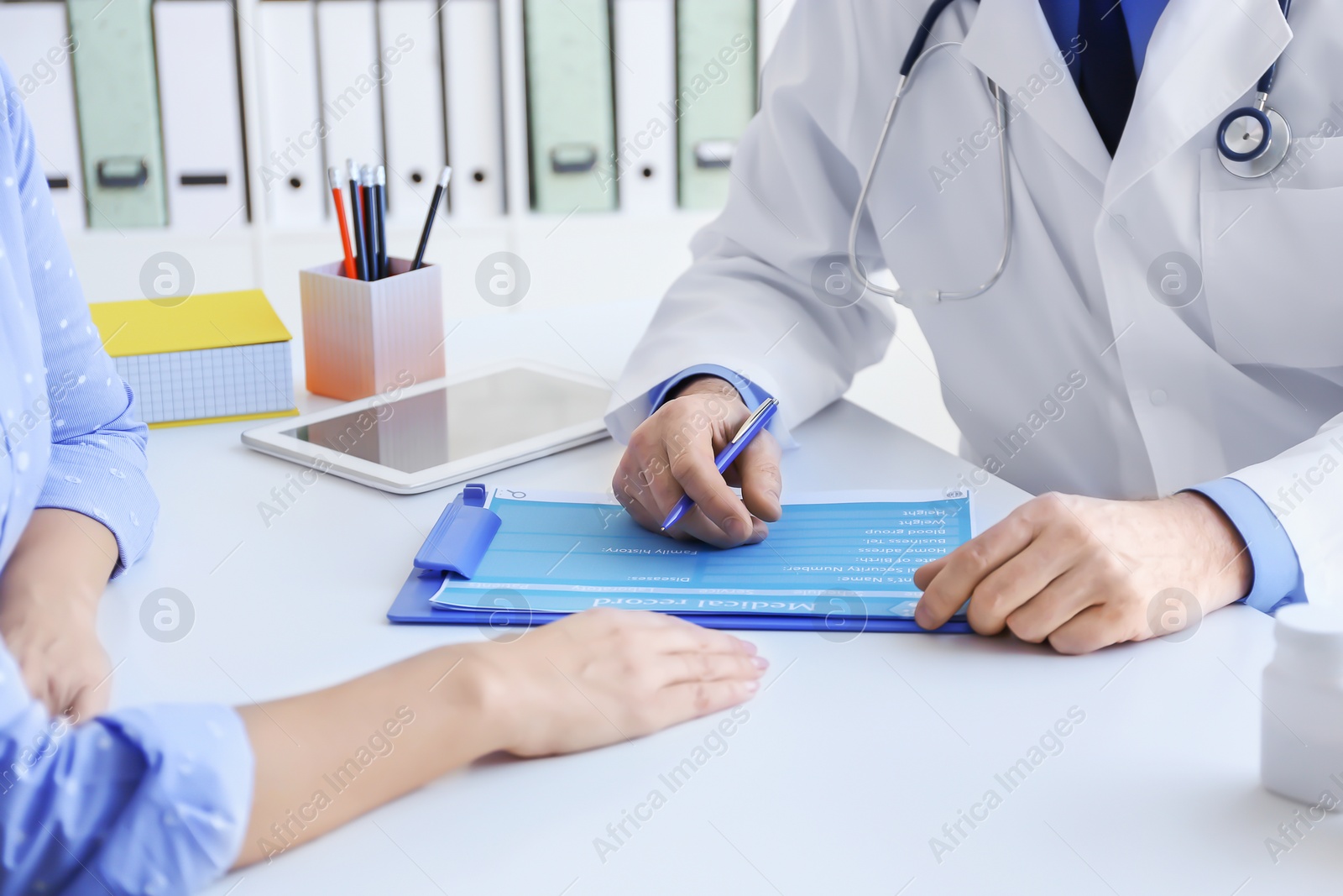 Photo of Mature doctor consulting patient in clinic