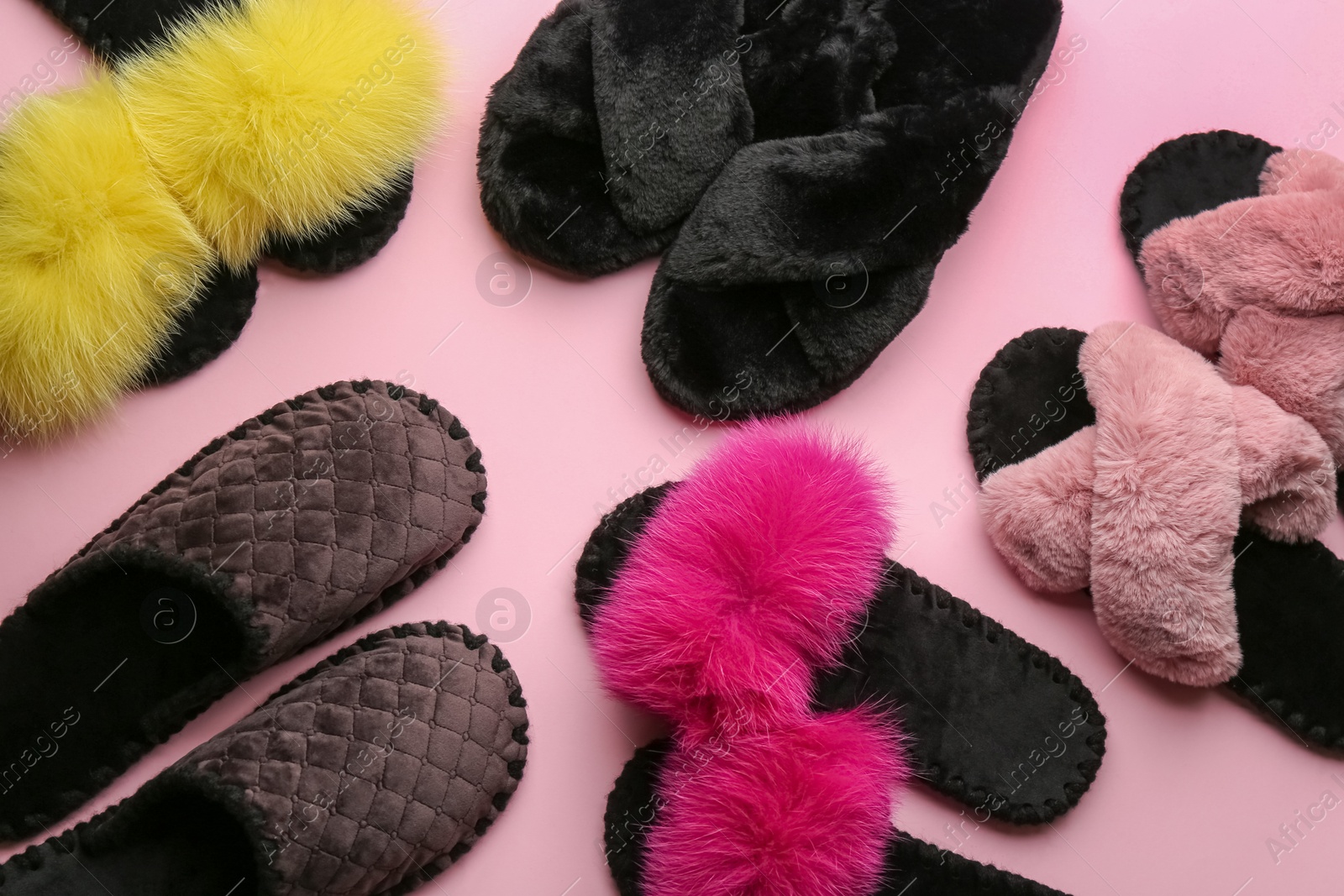 Photo of Different soft slippers on light pink background, flat lay
