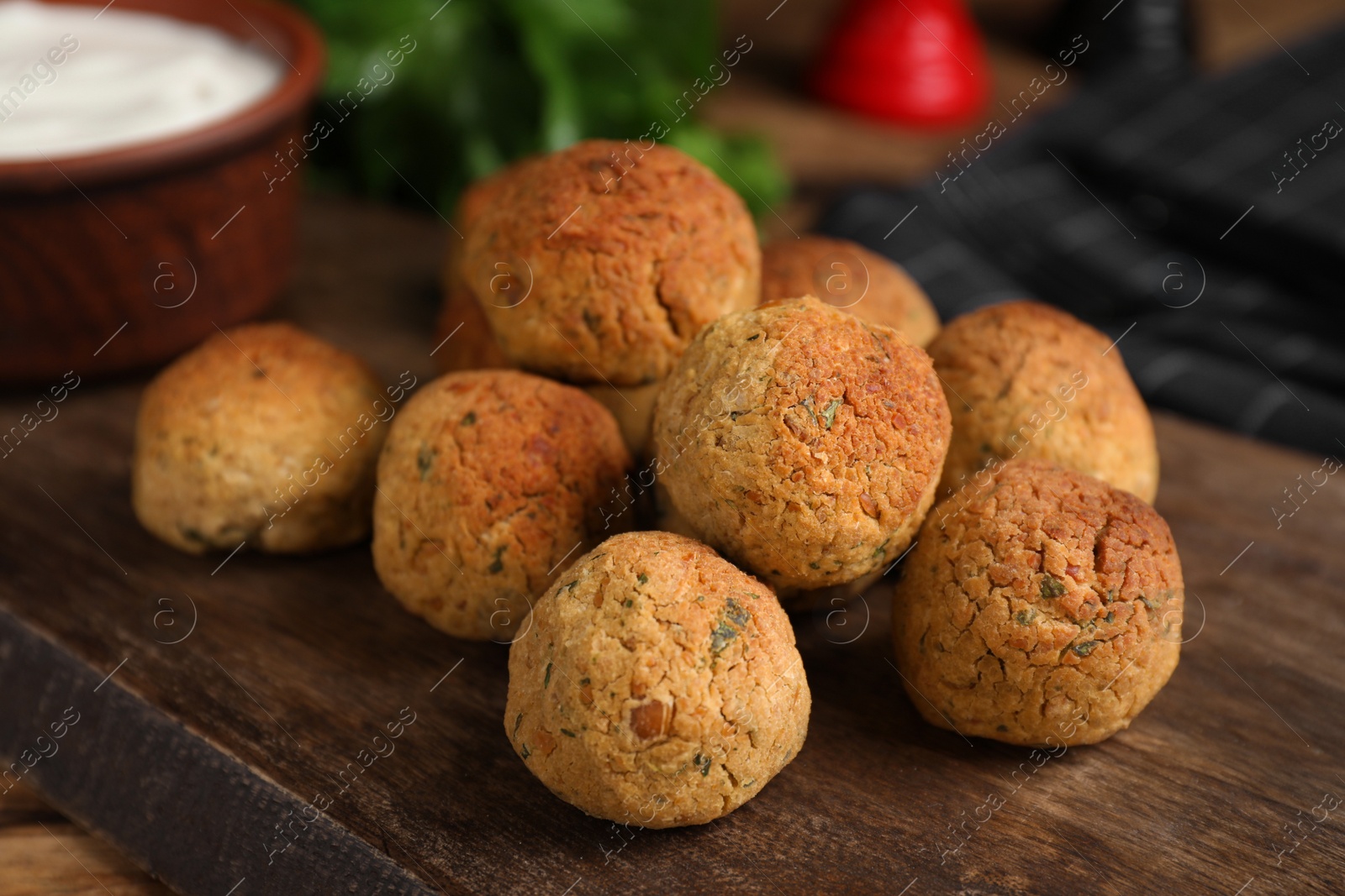 Photo of Delicious falafel balls on wooden board, closeup