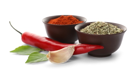 Different aromatic spices in bowls on white background