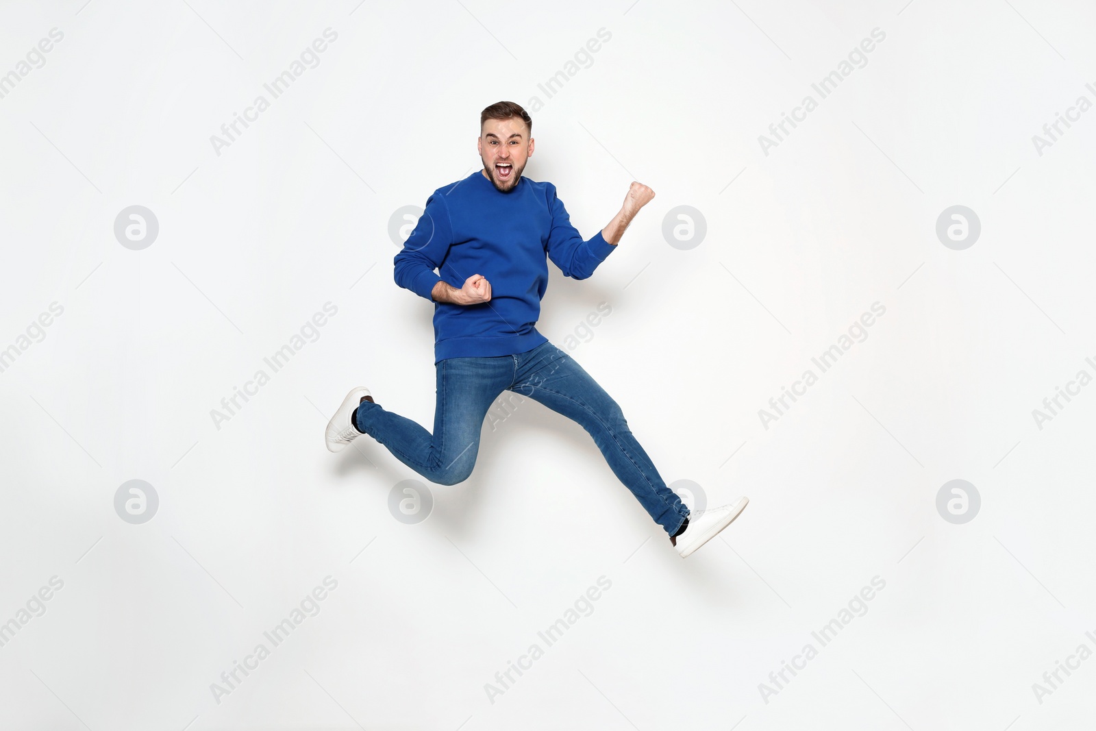 Photo of Full length portrait of handsome man jumping on white background