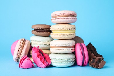 Photo of Pile of delicious colorful macarons on light blue background
