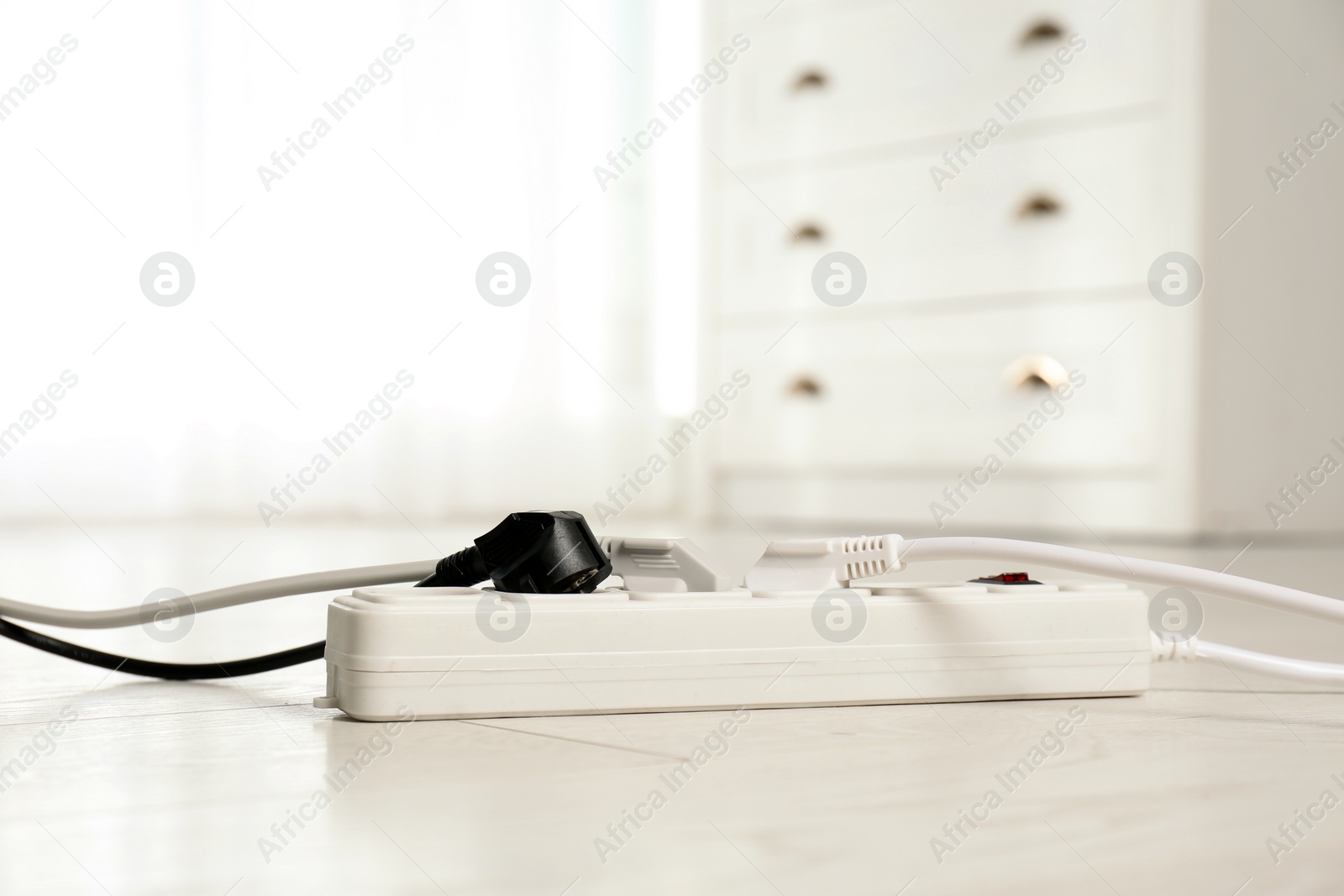 Photo of Extension cord on floor indoors, space for text. Electrician's professional equipment