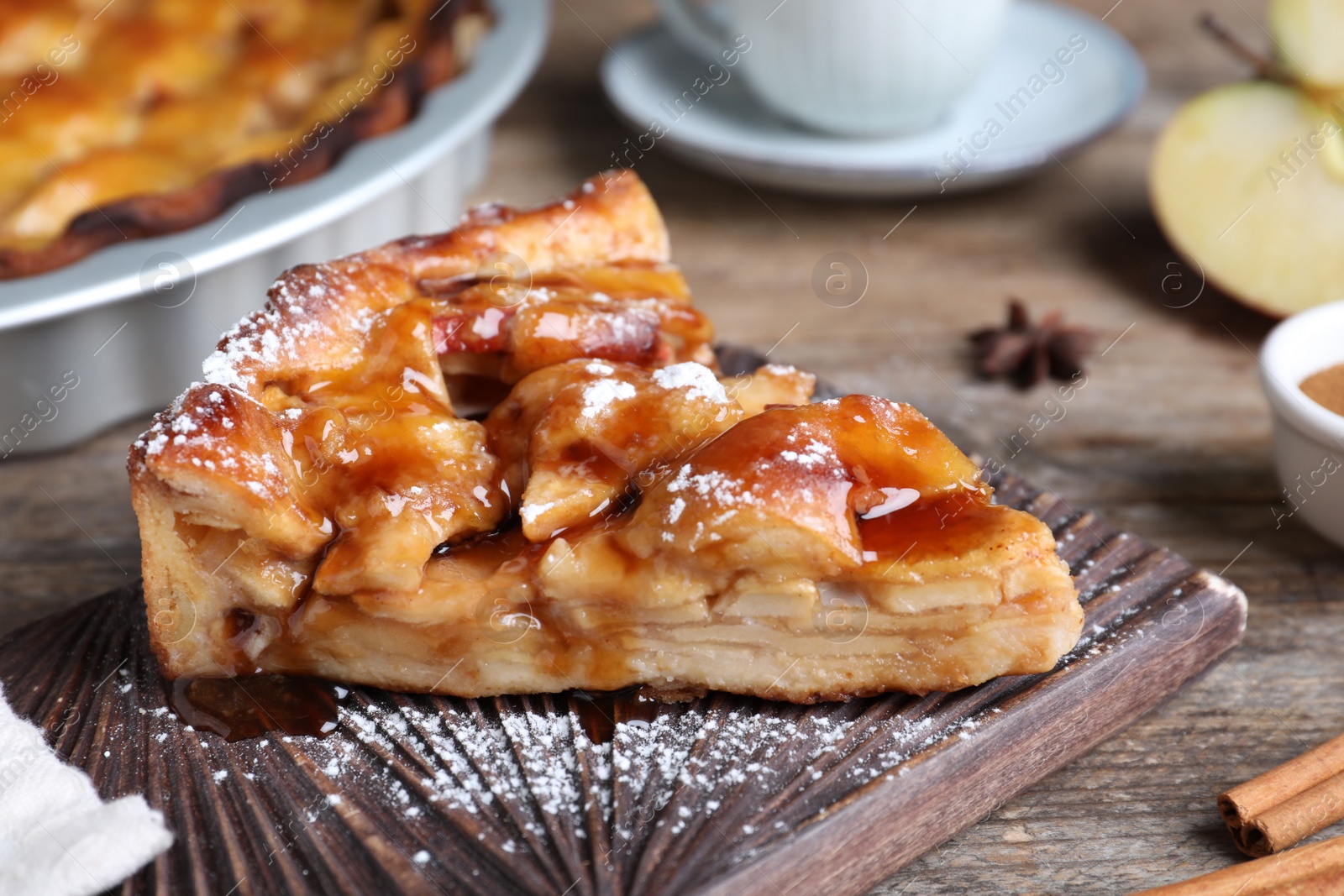 Photo of Slice of traditional apple pie served on wooden table, closeup