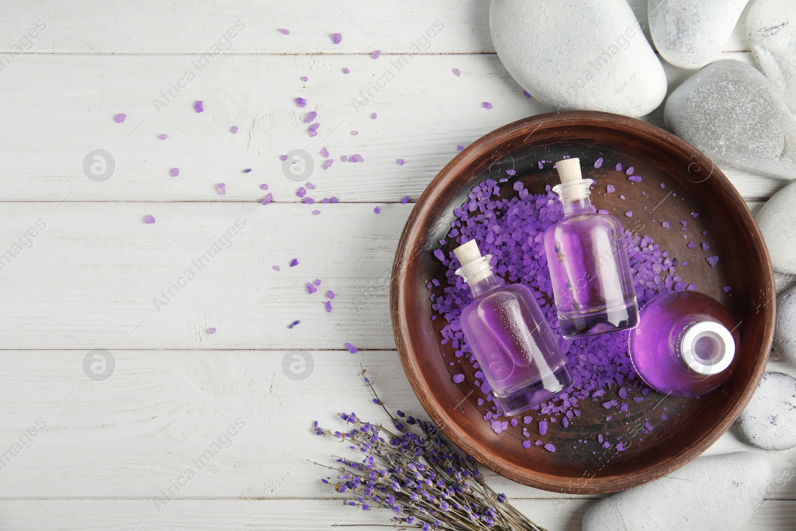 Photo of Flat lay composition with natural herbal oil and lavender flowers on wooden background. Space for text