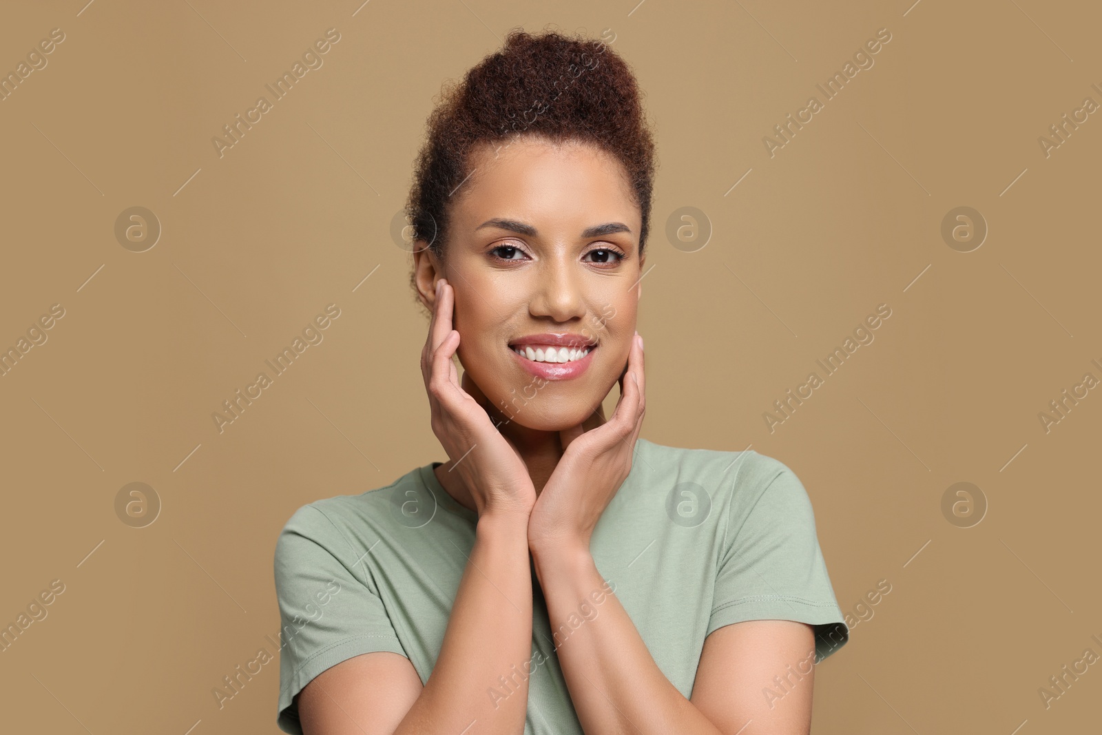 Photo of Portrait of beautiful young woman on light brown background