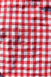 Red checkered picnic tablecloth as background, top view