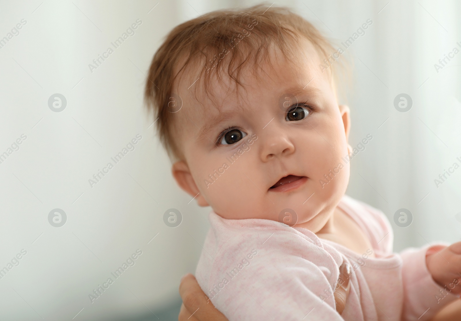 Photo of Young woman with her cute baby at home, closeup