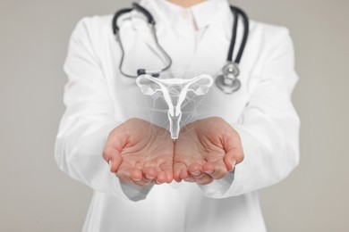 Image of Doctor and illustration of female reproductive system on grey background, closeup