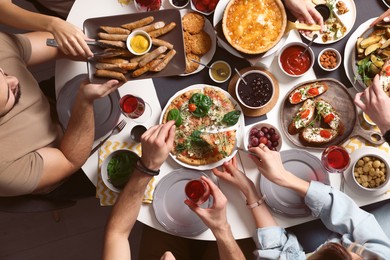 Photo of Group of people having brunch together at table indoors, top view