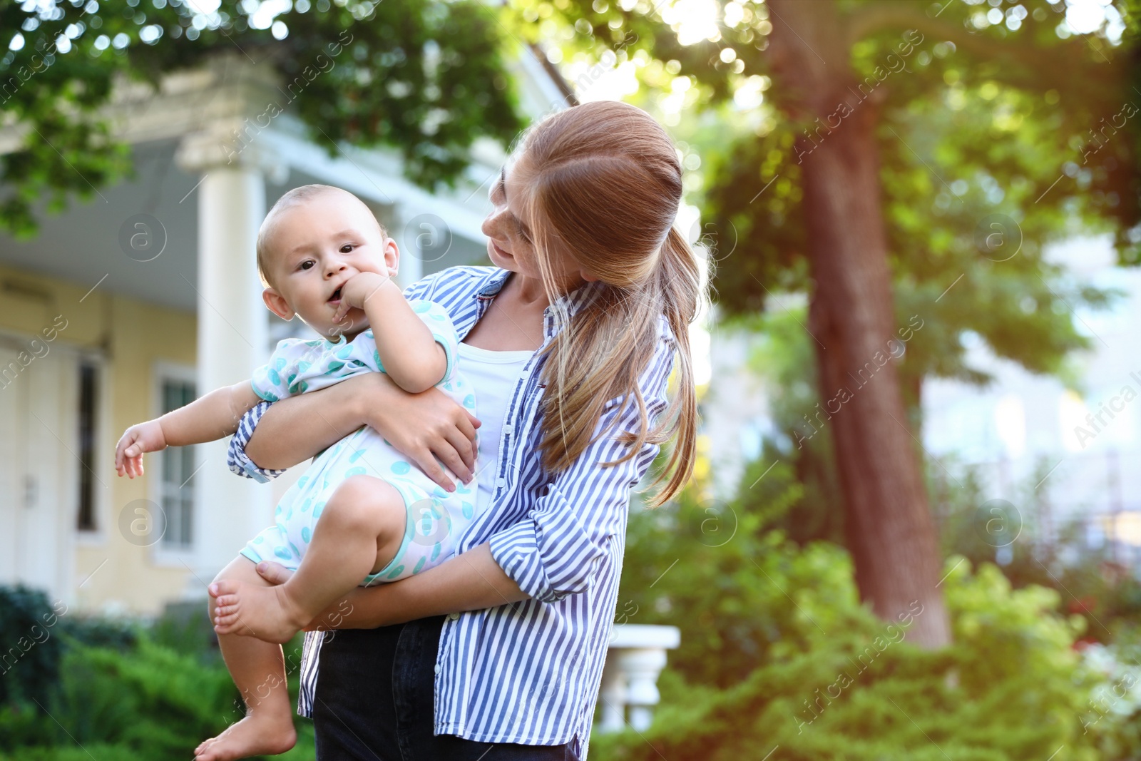 Photo of Teen nanny with cute baby outdoors on sunny day