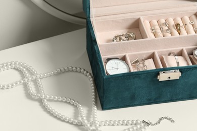Photo of Jewelry box with many different accessories on white table