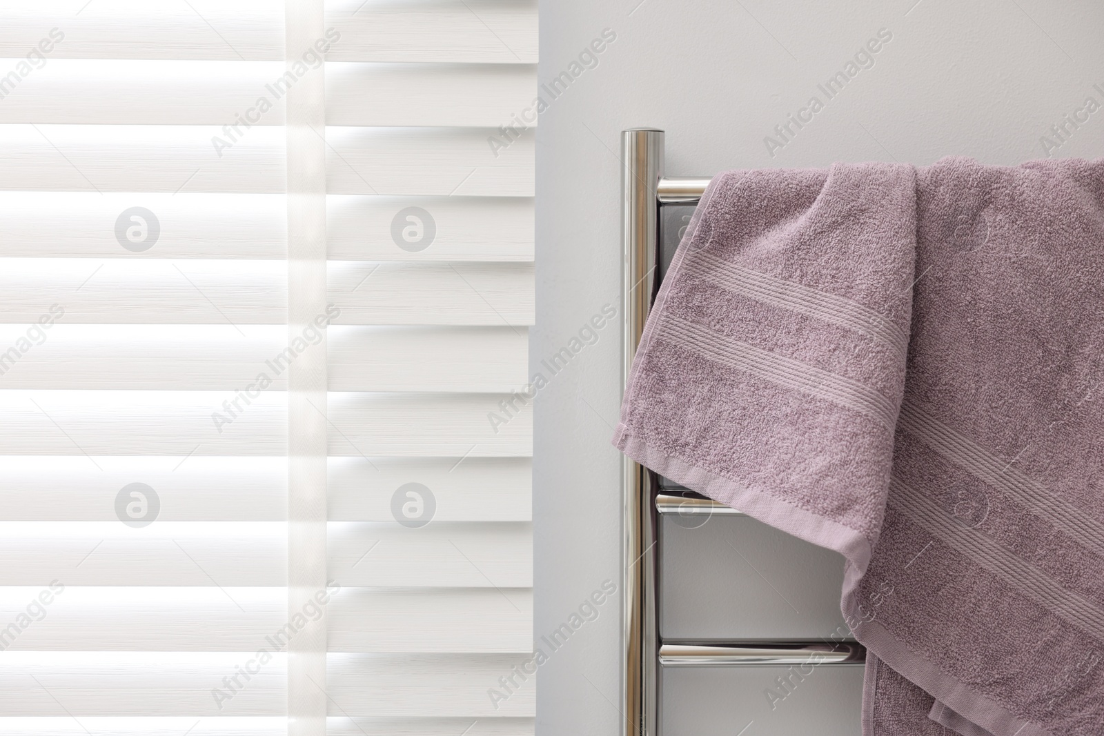 Photo of Clean terry towel on heated rail indoors