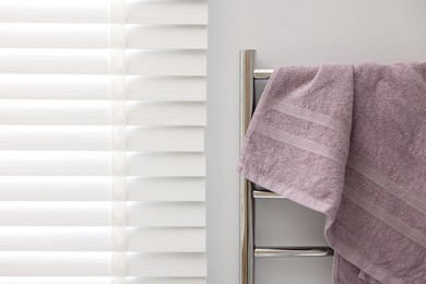 Photo of Clean terry towel on heated rail indoors
