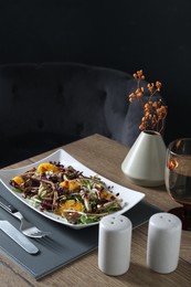 Photo of Delicious salad with beef tongue, orange and onion served on wooden table