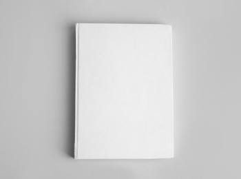 Book with blank cover on grey background, top view