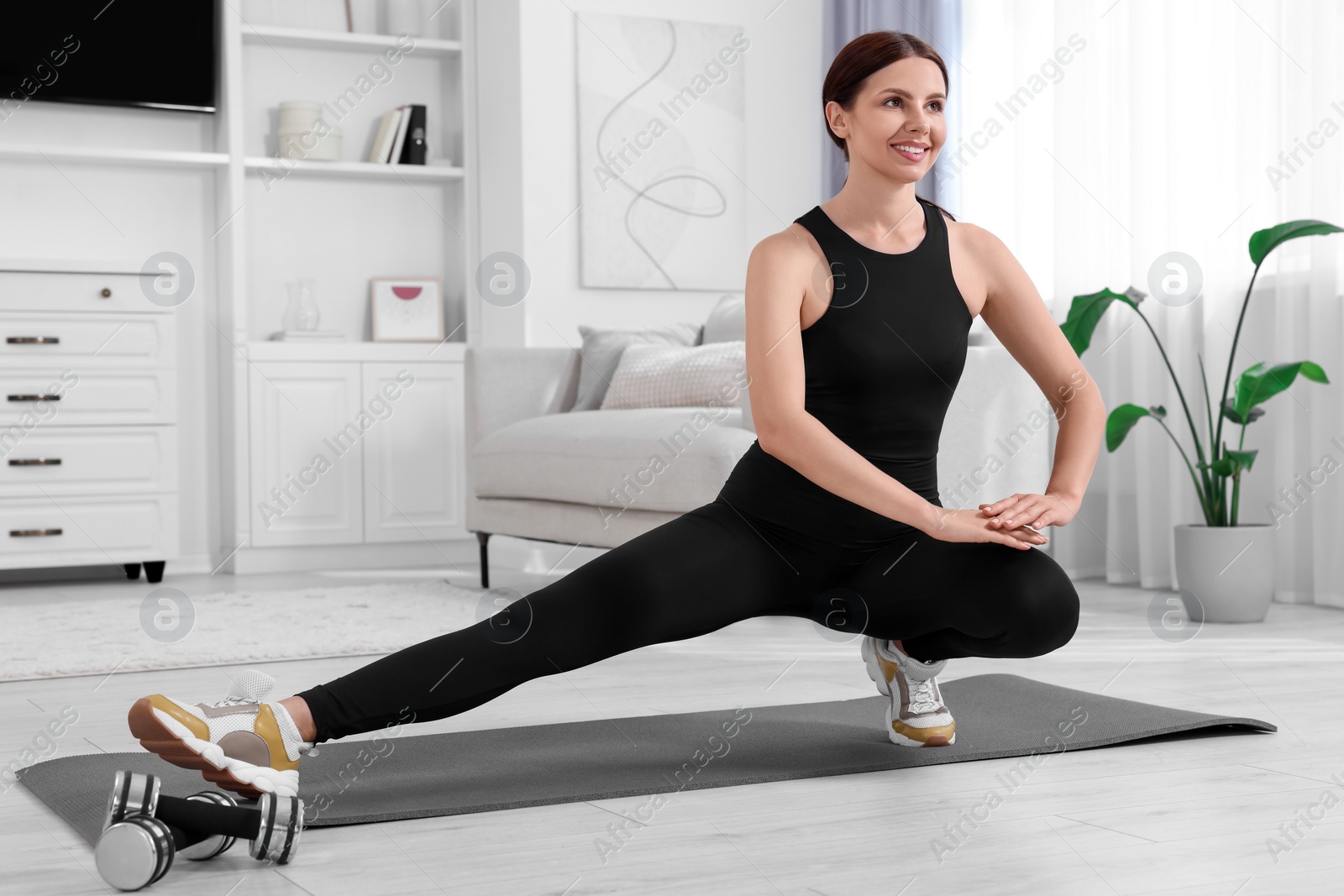 Photo of Morning routine. Happy woman doing stretching exercise at home. Space for text