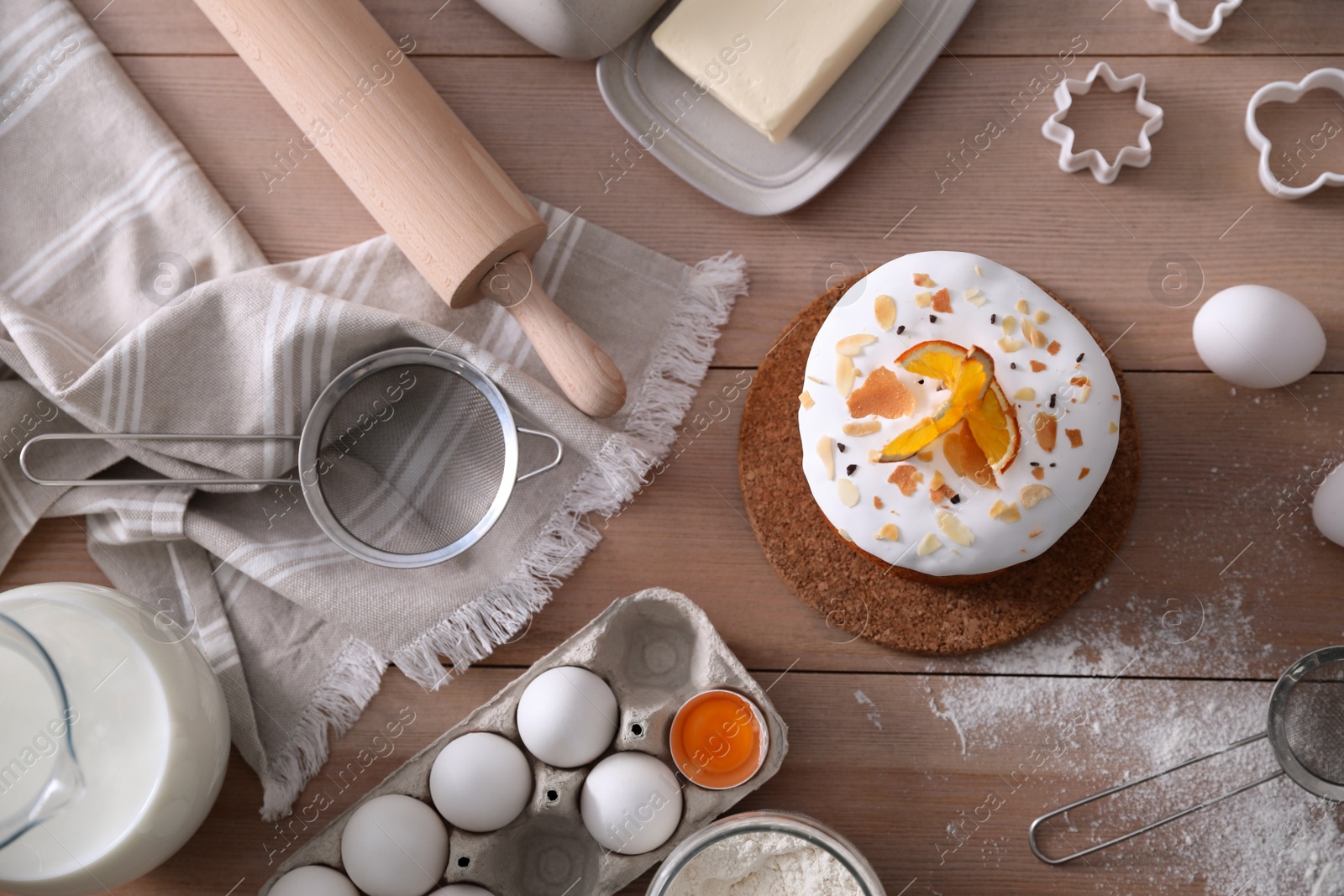 Photo of Flat lay composition with traditional Easter cake and ingredients on wooden table