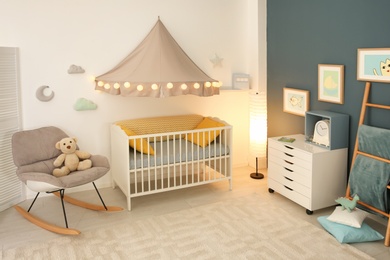 Stylish baby room interior with crib