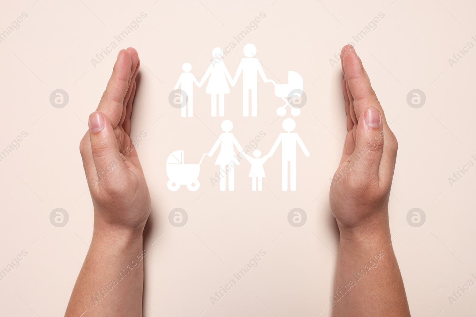 Image of Man holding hands around cutout paper silhouette of families on beige background, top view. Insurance concept