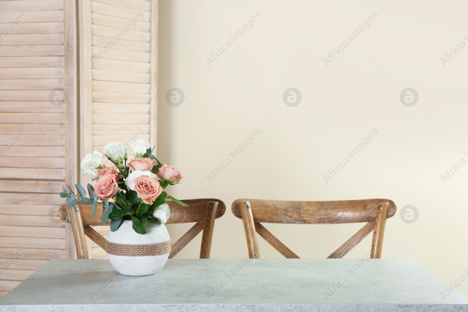 Photo of Vase with beautiful flowers as element of interior design on table in room. Space for text