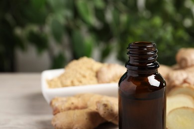 Photo of Ginger essential oil in bottle on table, closeup. Space for text