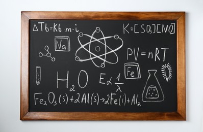 Blackboard with different chemical formulas written with chalk on white wall