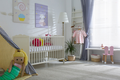 Photo of Baby room interior with cute posters, play tent and comfortable crib