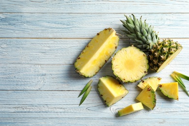 Flat lay composition with fresh sliced pineapple on wooden background