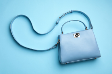 Photo of Stylish woman's bag on light blue background, top view