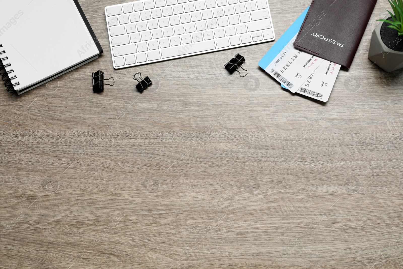 Photo of Flat lay composition with tickets, passport and keyboard on wooden table, space for text. Business trip