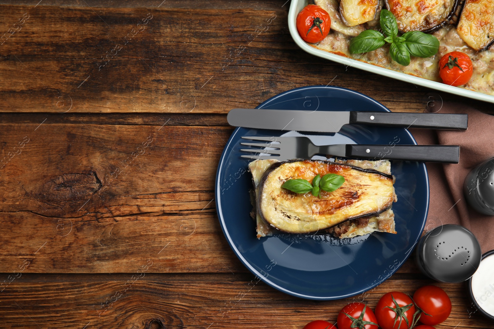 Photo of Delicious eggplant lasagna served on wooden table, flat lay. Space for text