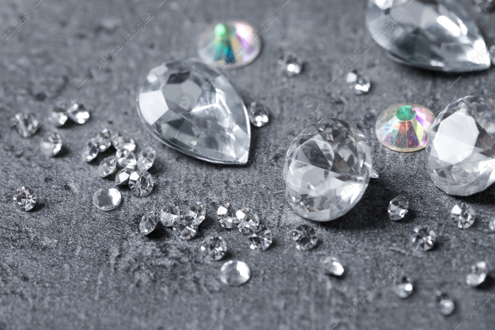 Photo of Beautiful gemstones for jewelry on grey background, closeup