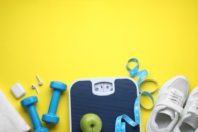 Flat lay composition with scales and measuring tape on yellow background, space for text