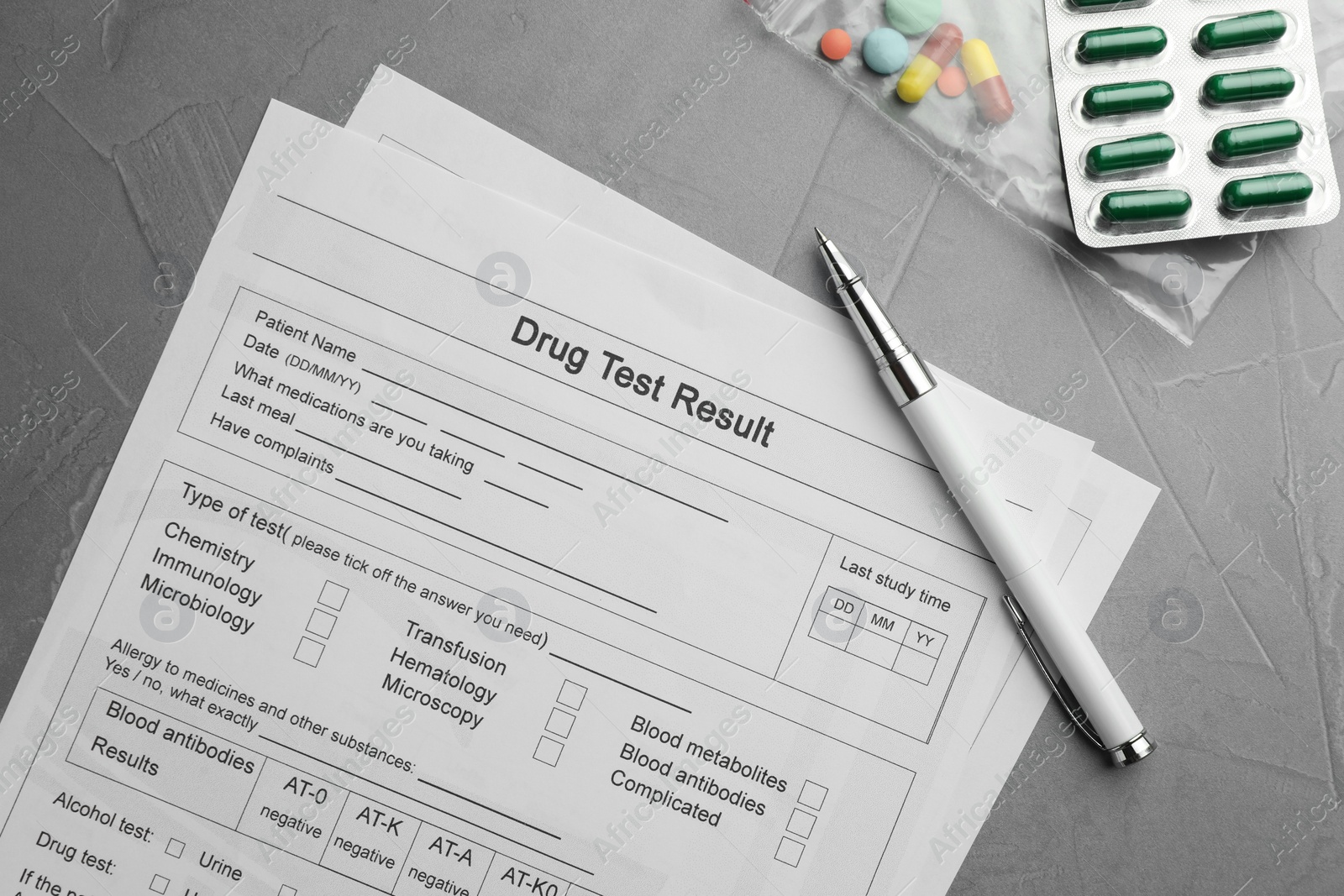 Photo of Drug test result form, pills and pen on grey table, flat lay