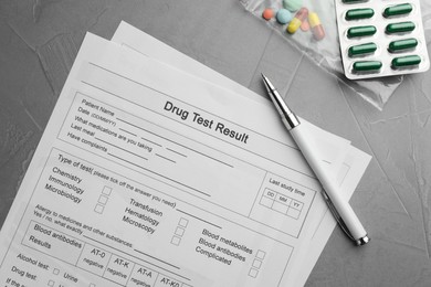 Drug test result form, pills and pen on grey table, flat lay