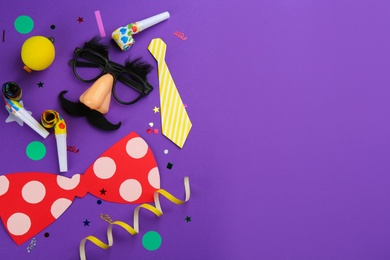 Flat lay composition with clown's accessories on purple background. Space for text