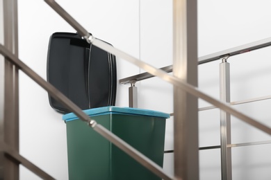 Photo of Trash bin on stair landing indoors. Waste recycling