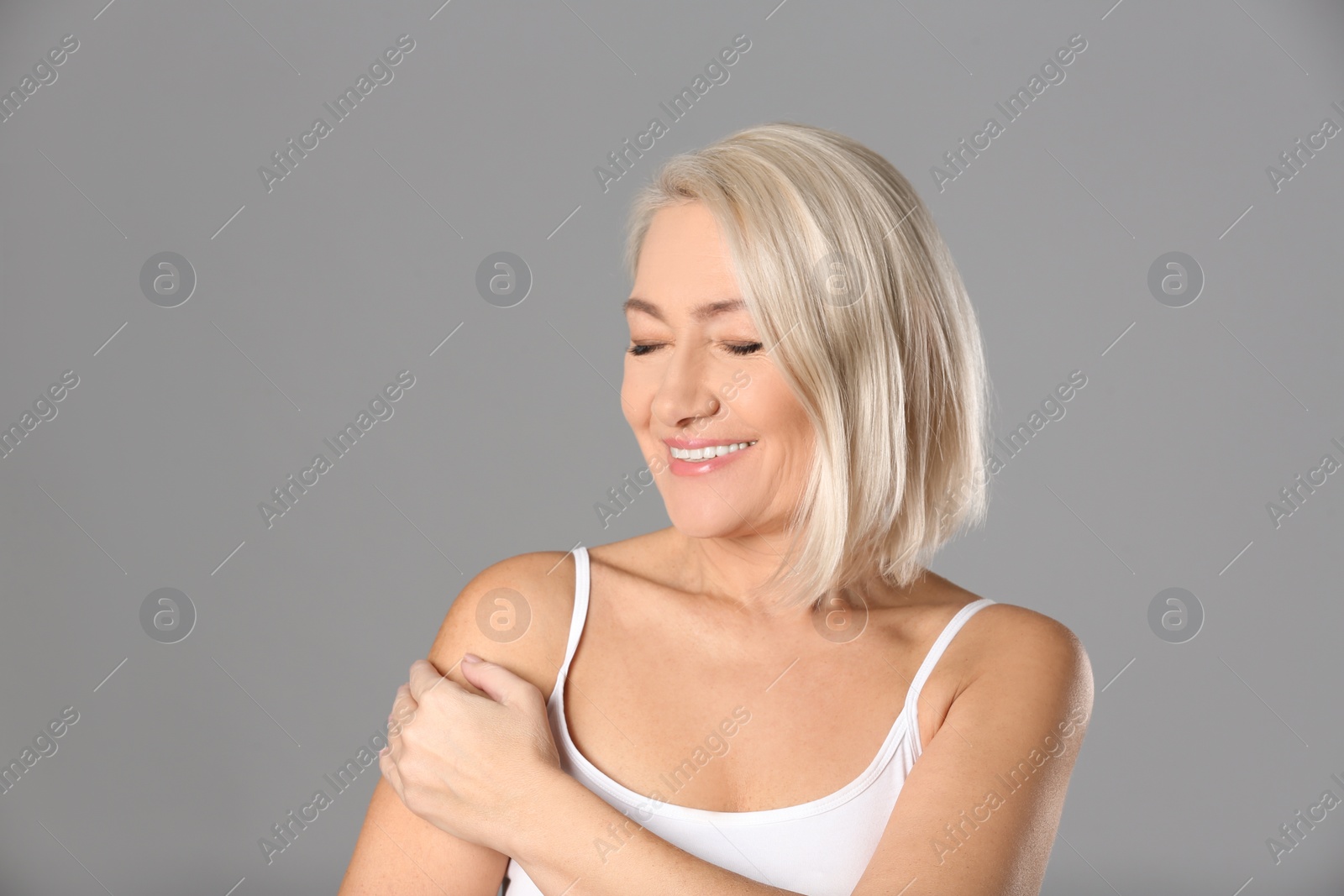 Photo of Portrait of beautiful mature woman on grey background