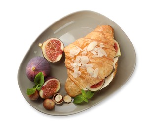 Delicious croissant with cream cheese, figs and hazelnuts isolated on white, top view