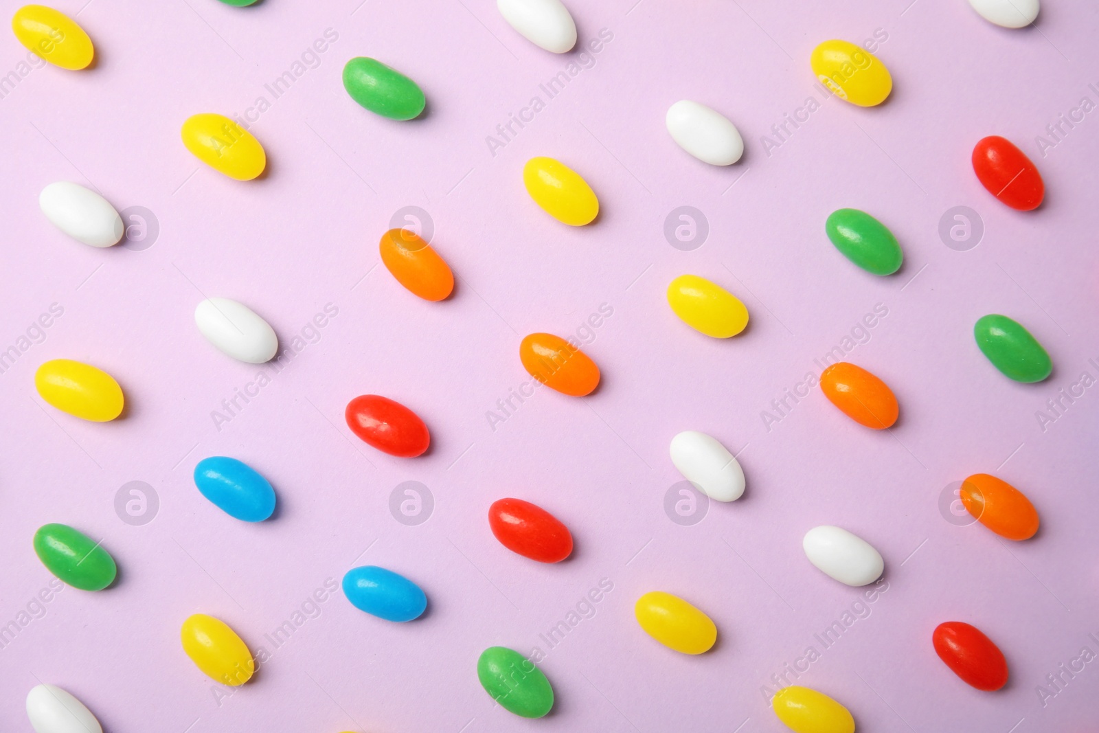 Photo of Flat lay composition with jelly beans on color background