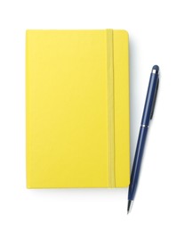 Photo of Closed yellow notebook with pen isolated on white, top view