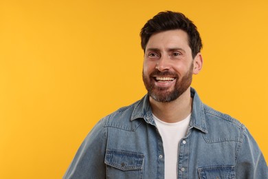 Photo of Handsome man laughing on yellow background. Space for text