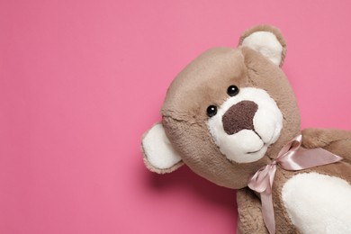 Photo of Cute teddy bear on pink background, top view. Space for text