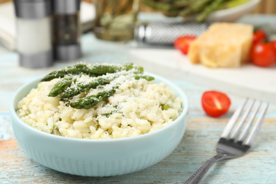 Delicious risotto with asparagus on wooden table, closeup