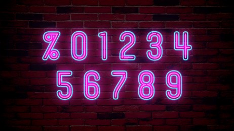 Image of Glowing neon number and percent signs on brick wall