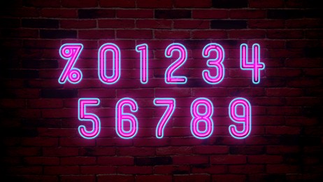 Glowing neon number and percent signs on brick wall